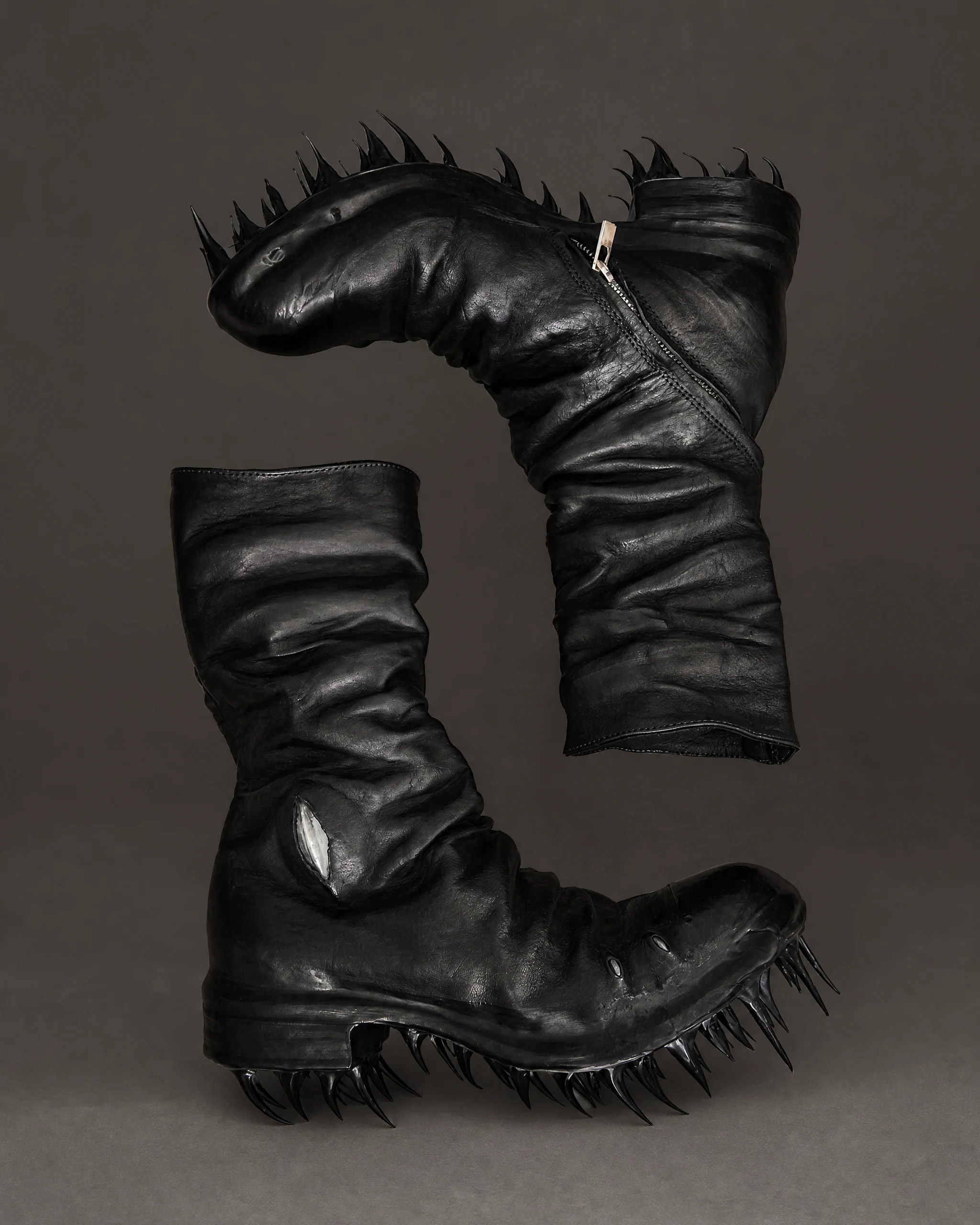 Pair of black draped leather boots with long spiked soles